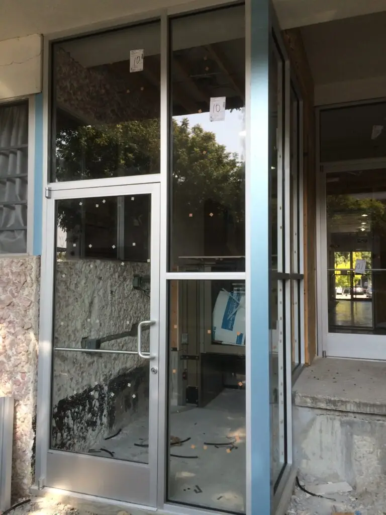 "Commercial door repair: repairing a damaged door frame and replacing it with a new one, demonstrating the process of fixing the door frame for enhanced security and functionality."